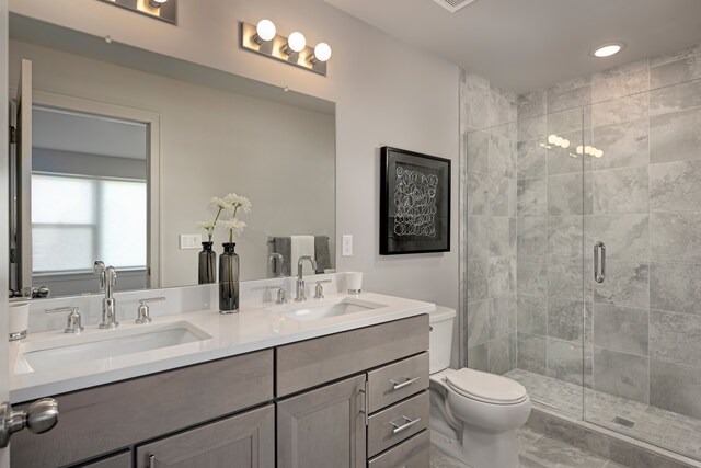 bathroom featuring vanity, toilet, and an enclosed shower