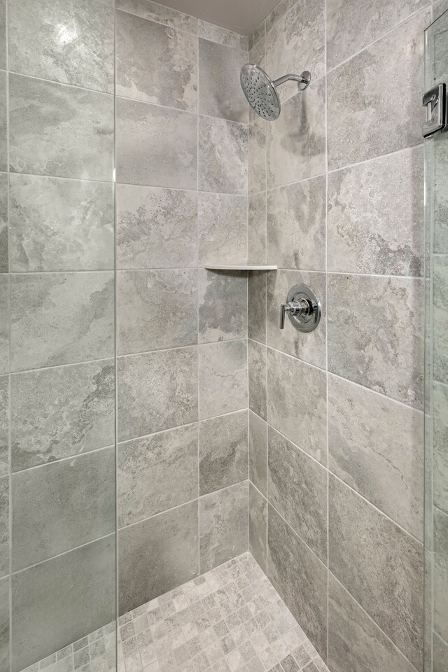 interior details featuring tiled shower