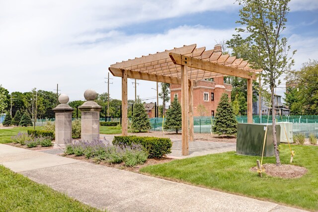 view of property's community with a pergola and a lawn