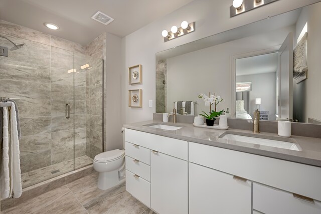 bathroom featuring vanity, an enclosed shower, and toilet