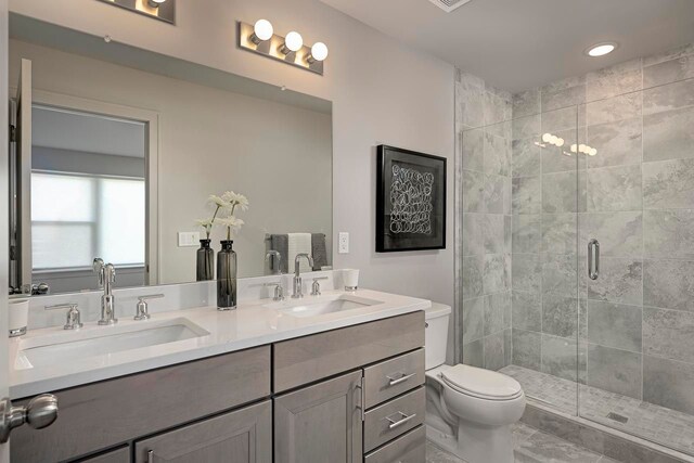 bathroom featuring vanity, an enclosed shower, and toilet