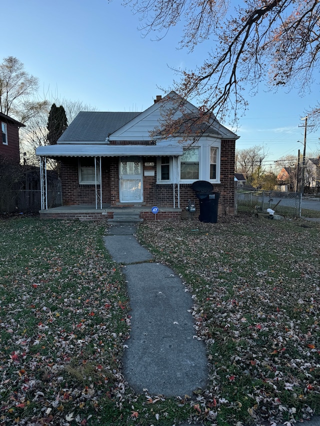 view of front of home with covered porch and a front lawn