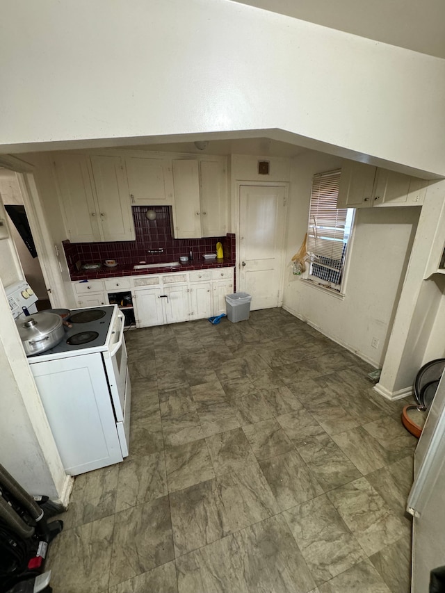 kitchen with backsplash, white range with electric cooktop, and sink