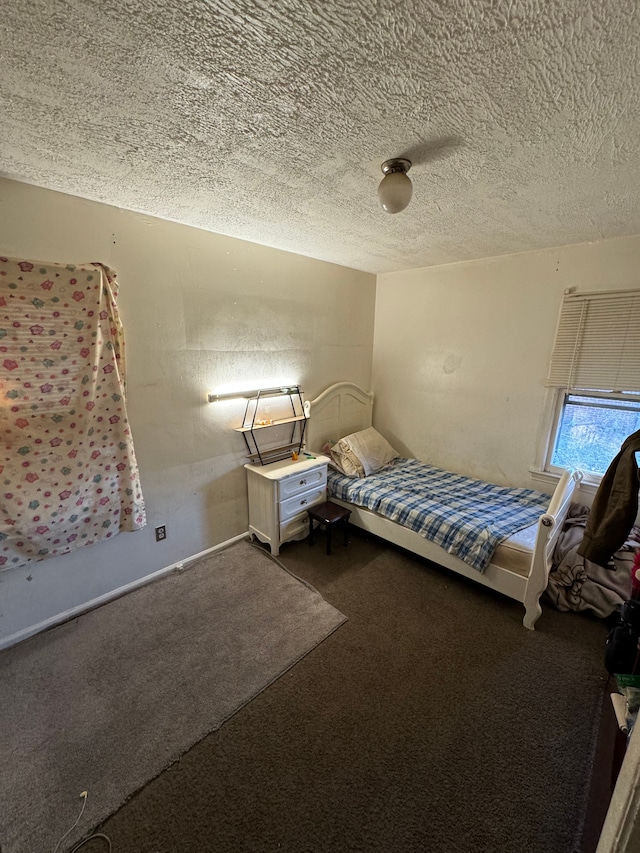 unfurnished bedroom with a textured ceiling and dark carpet