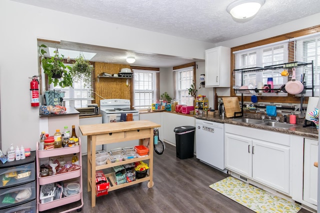 kitchen featuring dark hardwood / wood-style flooring, a textured ceiling, white appliances, sink, and white cabinets