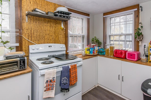 kitchen with white cabinets, dark hardwood / wood-style flooring, a textured ceiling, and white electric stove