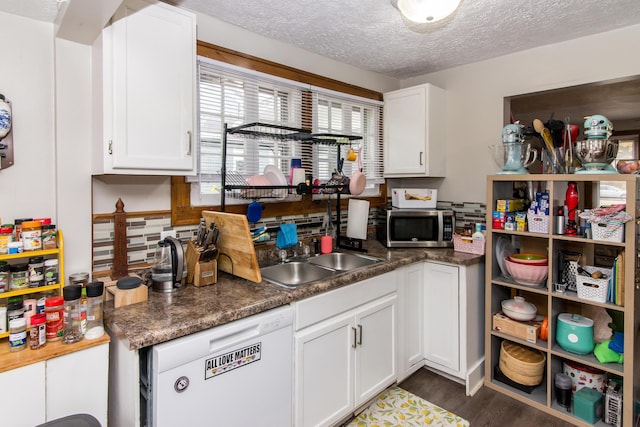 kitchen featuring dishwasher, dark hardwood / wood-style flooring, white cabinetry, and a textured ceiling