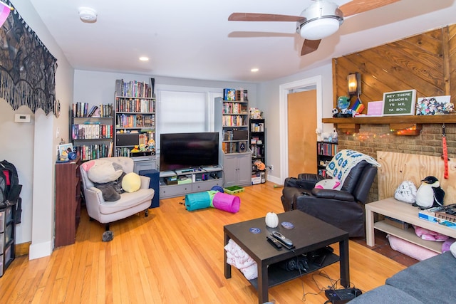 living room featuring ceiling fan and light hardwood / wood-style floors