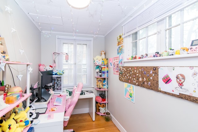 recreation room with light hardwood / wood-style floors and ornamental molding