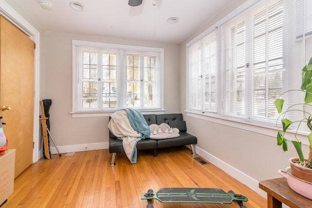 living area featuring light wood-type flooring and ceiling fan