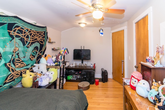 bedroom with a closet, hardwood / wood-style flooring, ceiling fan, and lofted ceiling