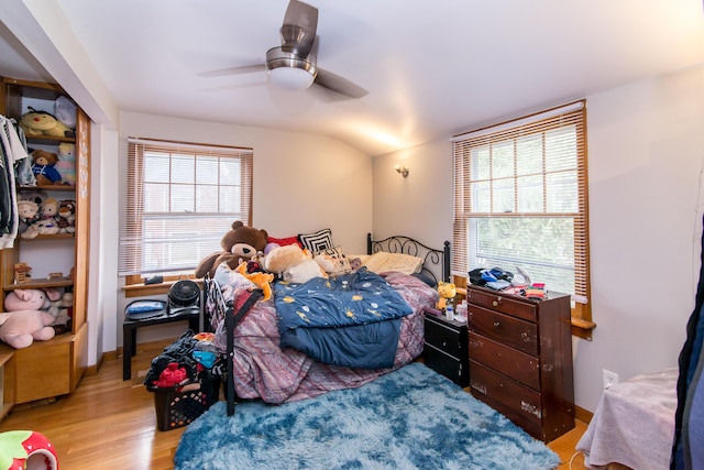 bedroom with ceiling fan, lofted ceiling, and light hardwood / wood-style flooring