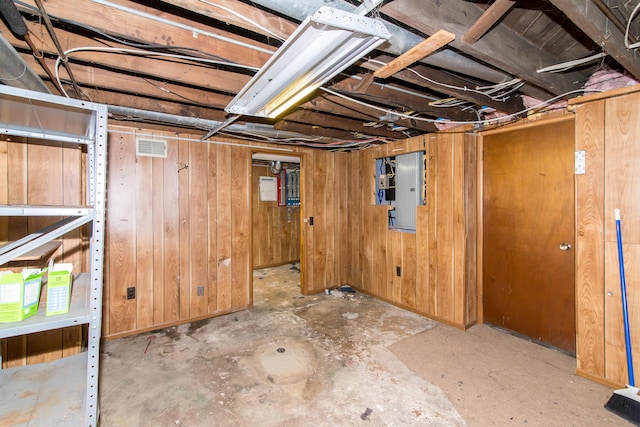 basement with electric panel and wood walls