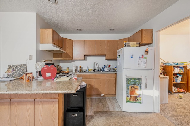 kitchen featuring sink, white fridge, light colored carpet, and a textured ceiling