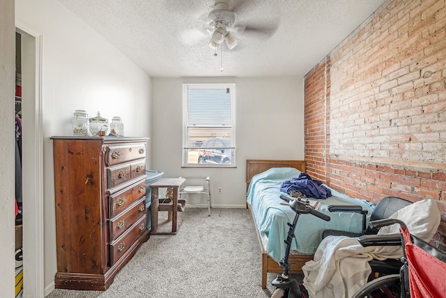 bedroom with ceiling fan, light colored carpet, and a textured ceiling