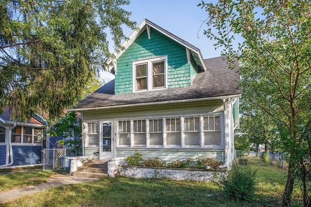 view of front of home featuring a sunroom and a front yard