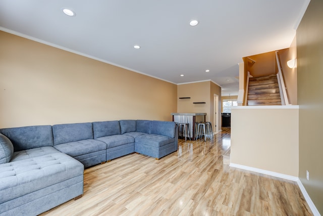 living room with light wood-type flooring and crown molding