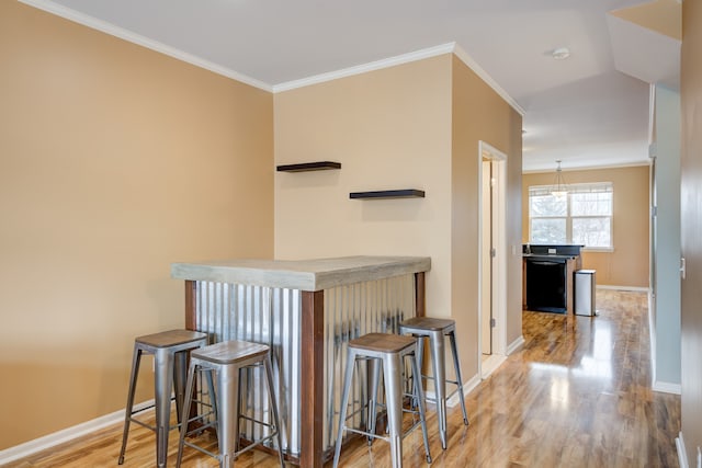 interior space with dishwasher, light hardwood / wood-style floors, and ornamental molding