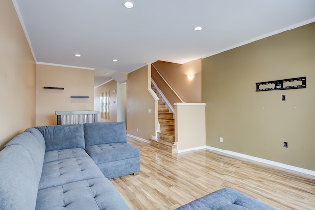 living room with light wood-type flooring and ornamental molding