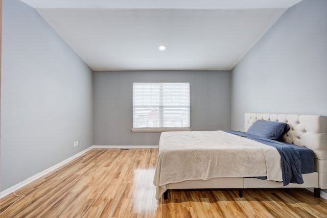 bedroom featuring vaulted ceiling and light hardwood / wood-style flooring