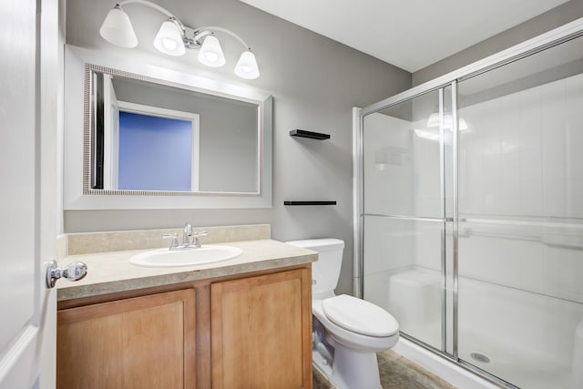 bathroom featuring vanity, an enclosed shower, and toilet