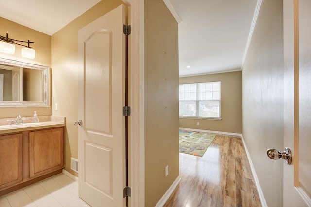 bathroom featuring hardwood / wood-style flooring, vanity, and ornamental molding