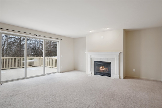 unfurnished living room featuring a tile fireplace and light colored carpet