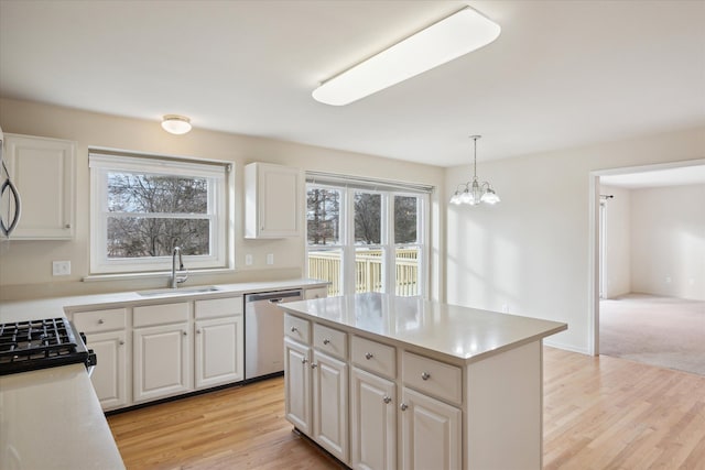 kitchen with dishwasher, pendant lighting, white cabinets, and sink