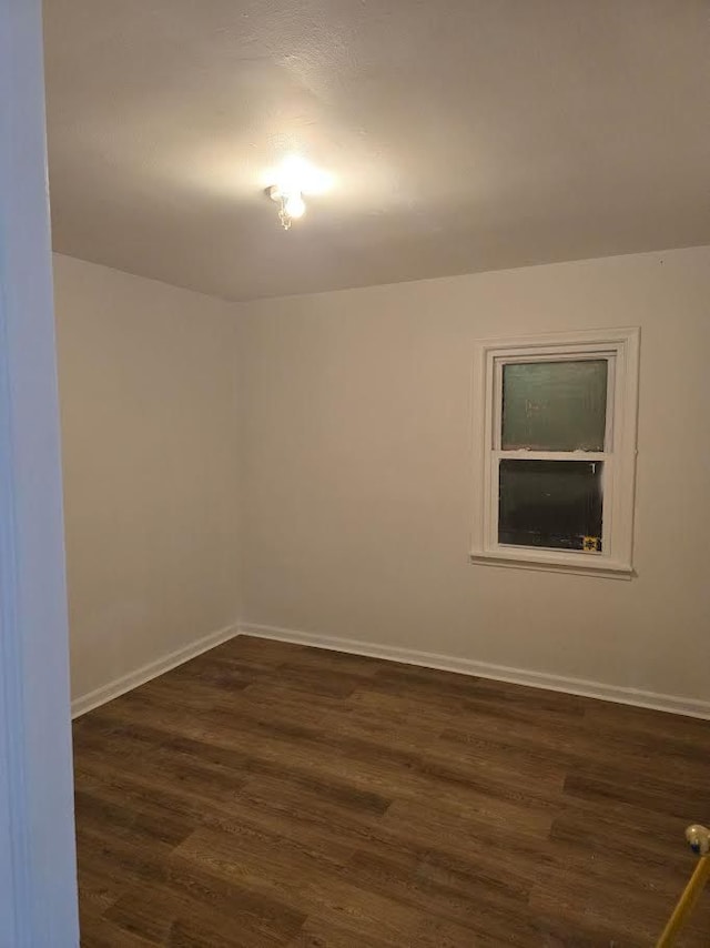 unfurnished room with dark wood-type flooring