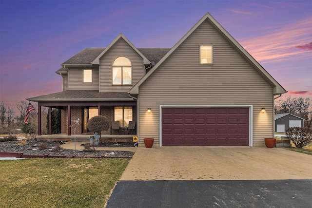 view of front facade featuring a porch, a garage, and a yard