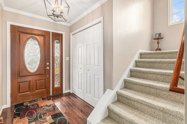 foyer featuring an inviting chandelier, ornamental molding, and dark hardwood / wood-style floors