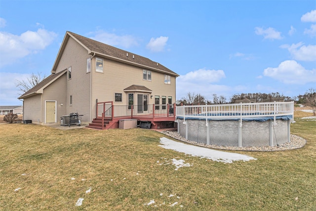 back of house with a pool side deck and a lawn