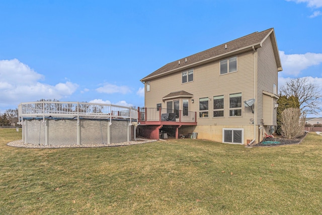 rear view of house with a pool side deck and a lawn