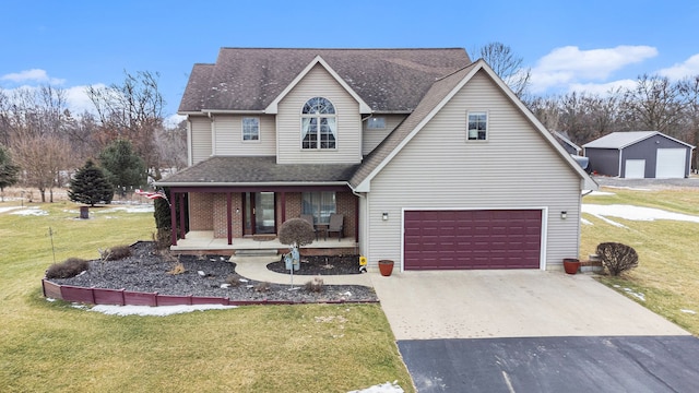 view of property with a garage, covered porch, and a front yard