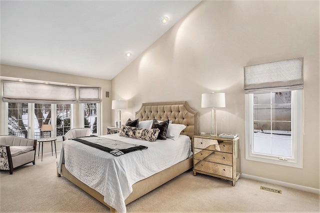 carpeted bedroom with high vaulted ceiling and multiple windows