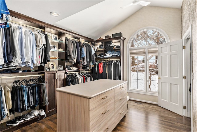 walk in closet with dark wood-type flooring and lofted ceiling