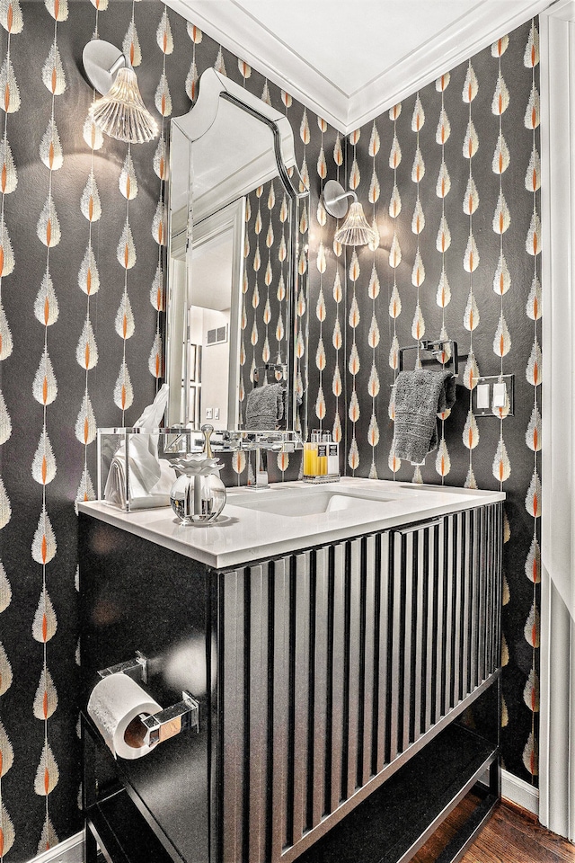 bathroom featuring ornamental molding, hardwood / wood-style floors, and sink