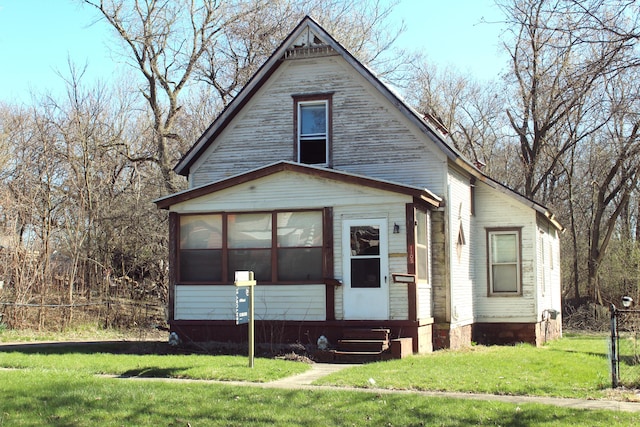 view of front of property featuring a sunroom and a front yard