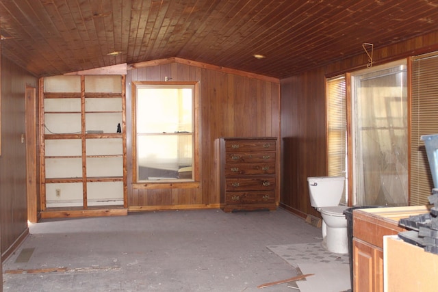 interior space with wooden walls, vaulted ceiling, and toilet