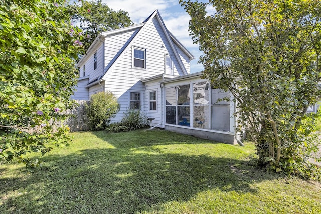 back of property featuring a sunroom and a yard