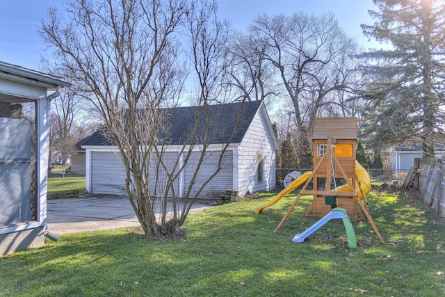 view of yard featuring a garage, an outdoor structure, and a playground