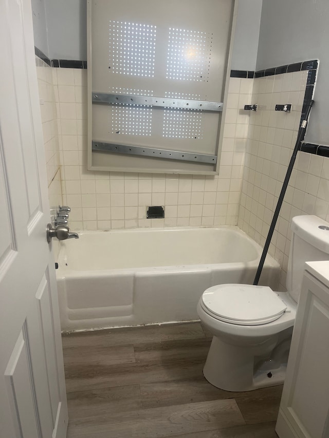 bathroom with toilet, vanity, tile walls, and hardwood / wood-style flooring