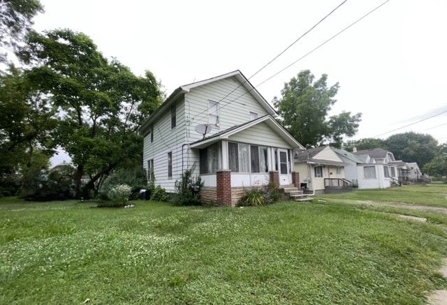 view of home's exterior featuring a lawn and a sunroom