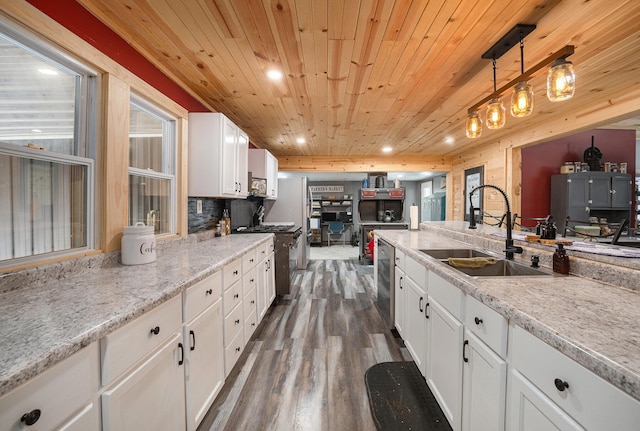 kitchen with wooden ceiling, white cabinets, sink, appliances with stainless steel finishes, and decorative light fixtures