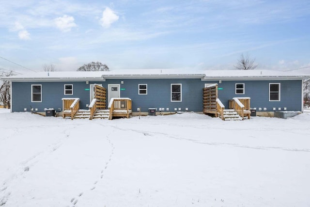 view of snow covered back of property