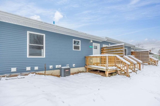 snow covered rear of property with central air condition unit