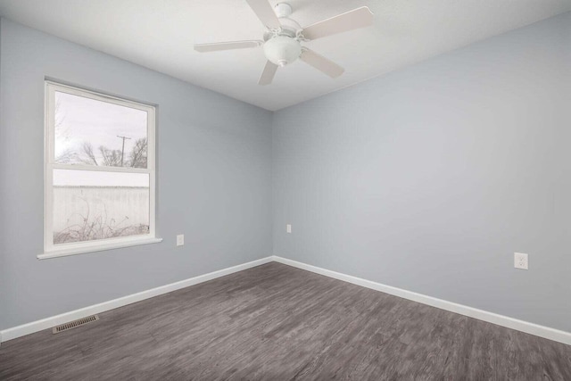 empty room with ceiling fan and dark hardwood / wood-style flooring