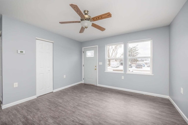 unfurnished room with ceiling fan and dark wood-type flooring