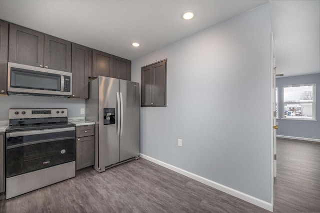 kitchen with dark brown cabinetry, stainless steel appliances, and light hardwood / wood-style floors