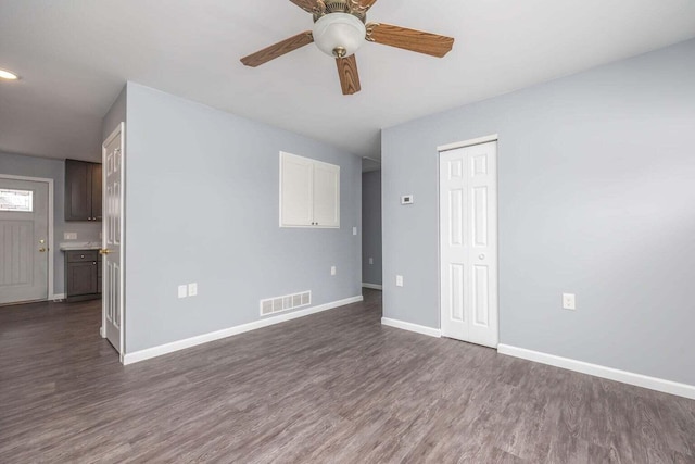 spare room featuring ceiling fan and dark wood-type flooring